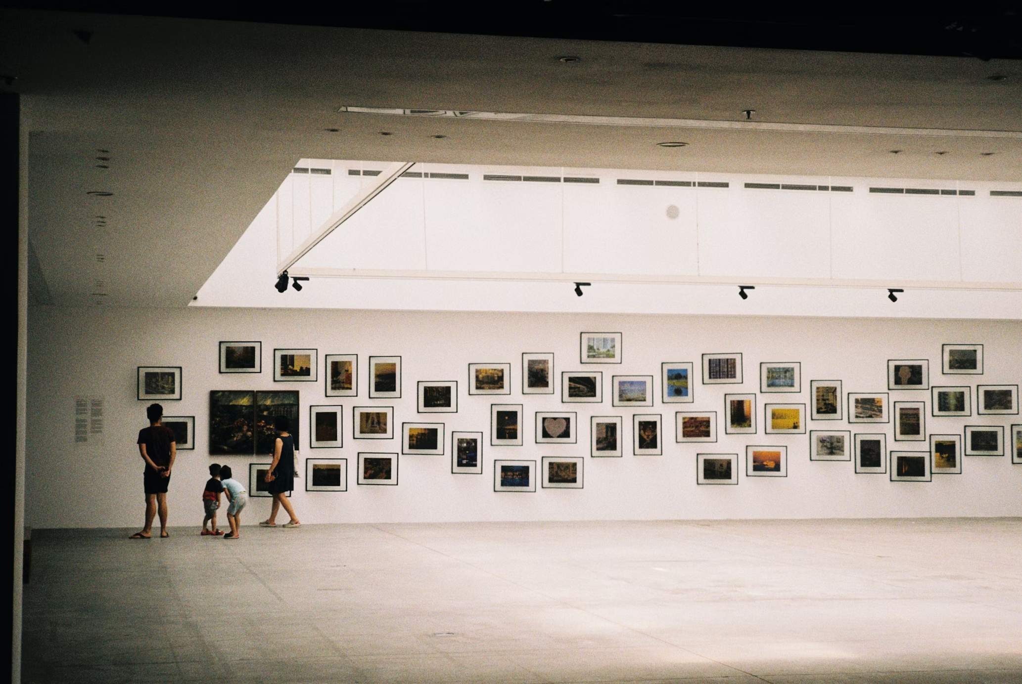 Visitors viewing framed artworks in a gallery